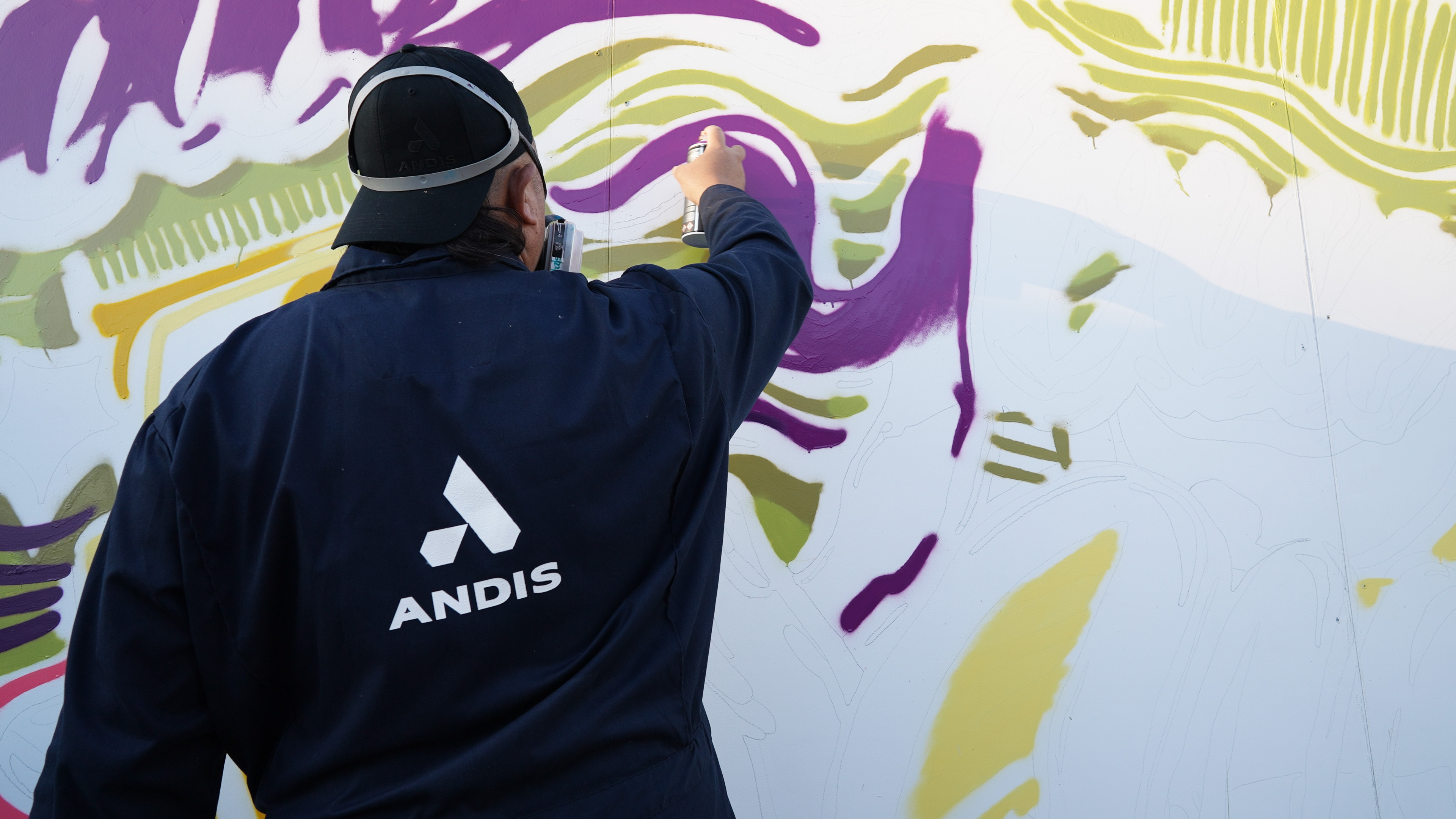 Brighter Community Venice Beach man spray painting on mural in purple