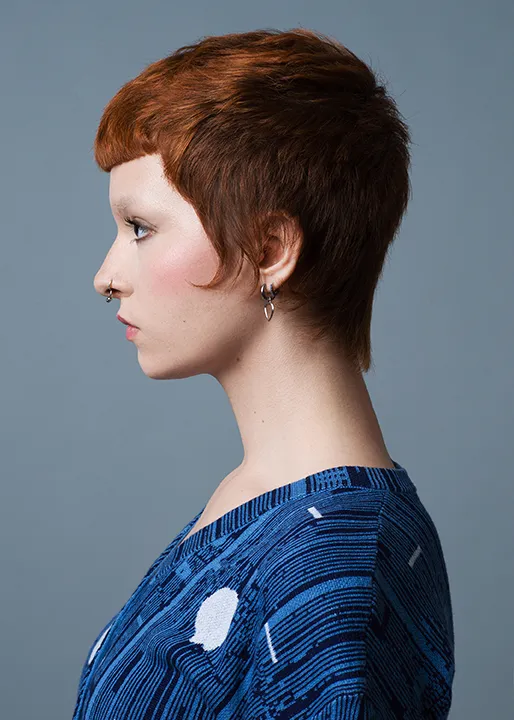 Female model with red hair shows off Tender Flow Mullet hairstyle.