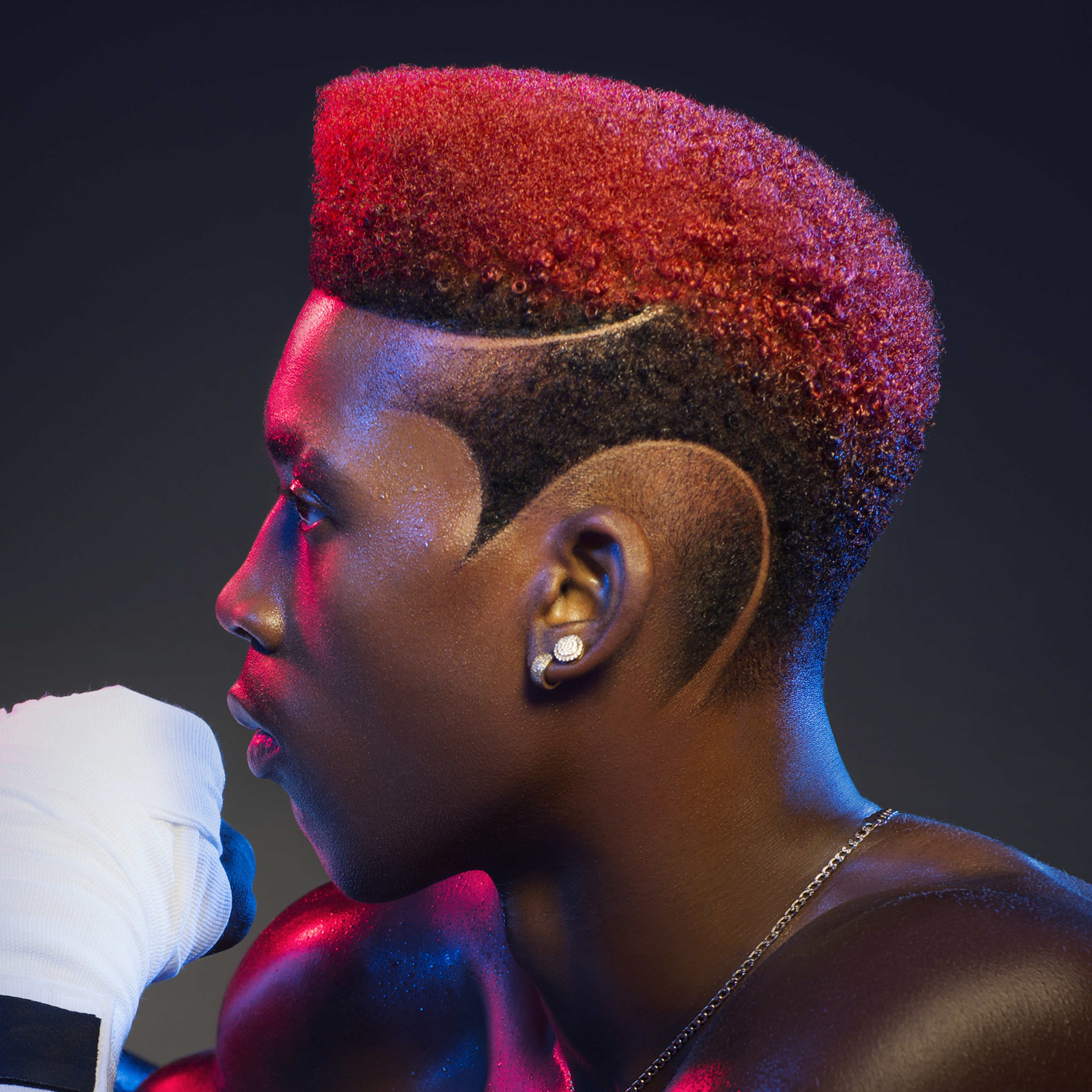 African American male boxer modeling three-arc fade design on the side of his head by Andis.
