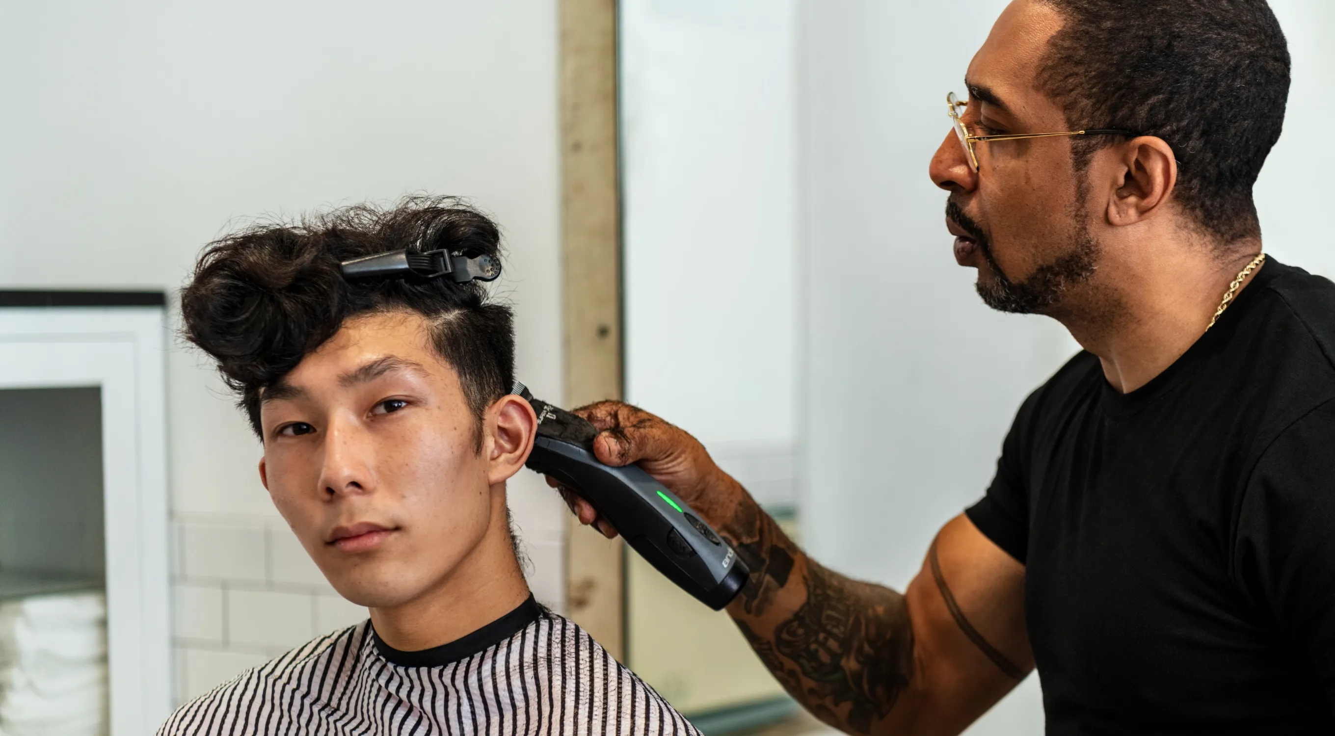 Large image of Young man in barber chair getting hair cut